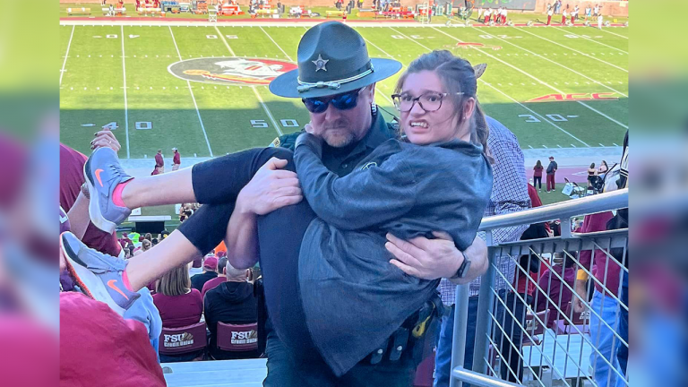 Girl Struggled with Stairs in A Football Stadium and Image of Police Officer Carrying Her Went Viral