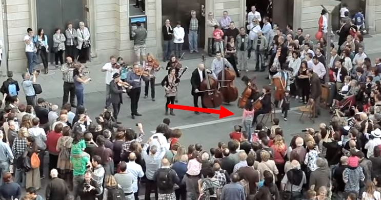 A little girl gives coins to a street musician, and gets the best surprise in return
